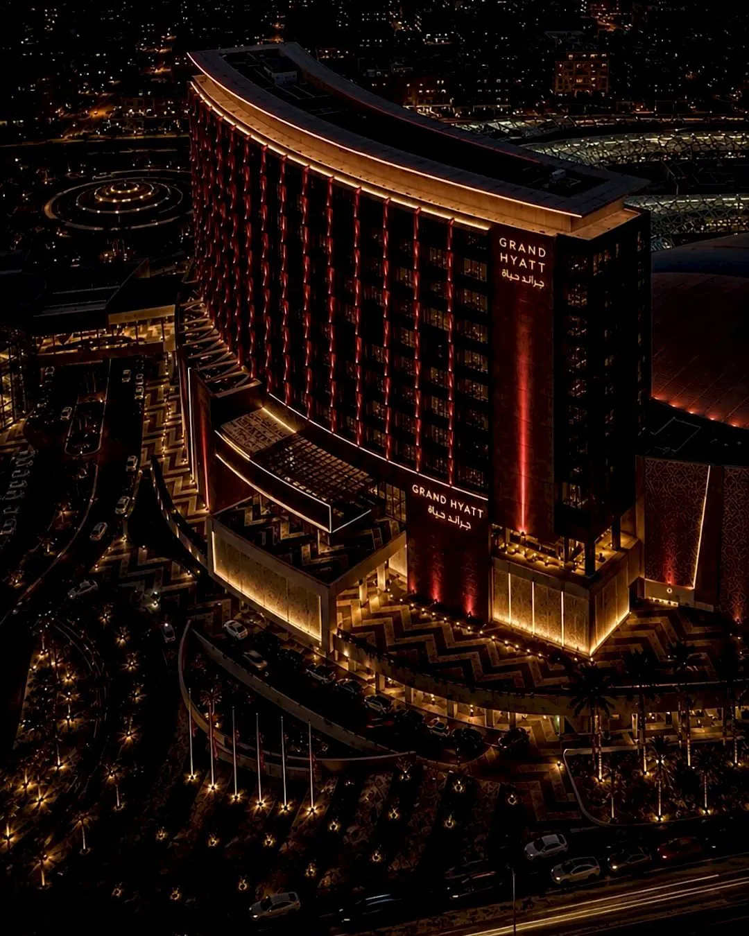 Aerial night view of the Grand Hyatt Hotel lit in warm gold and red