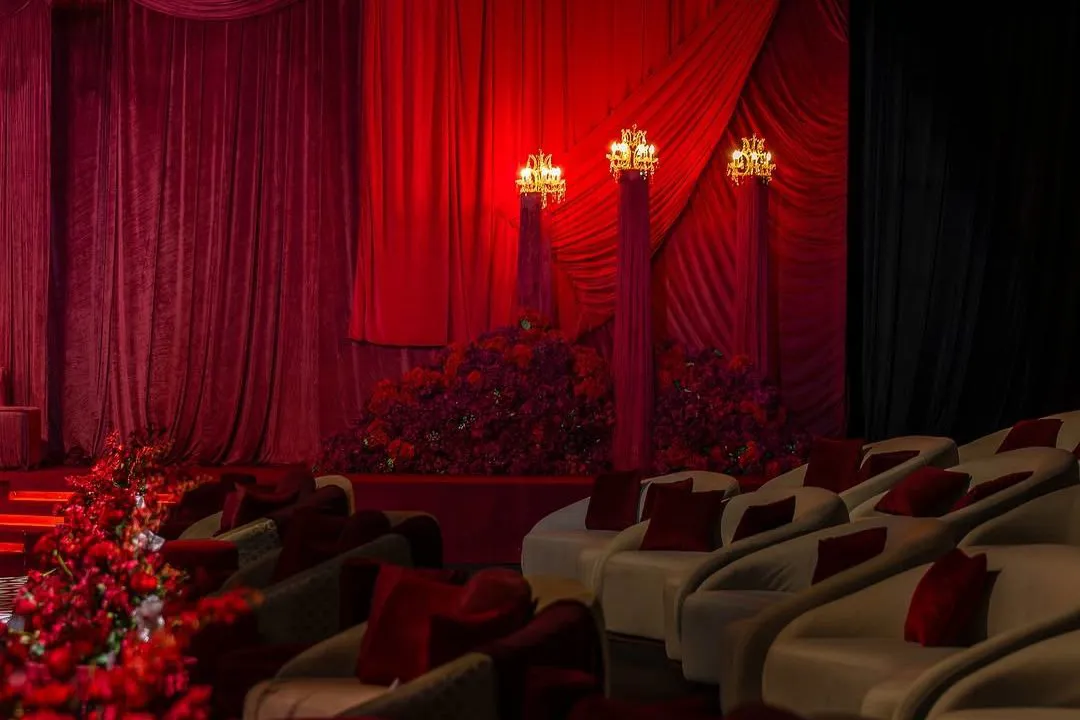 Rows of VIP lounge seating with red cushions facing the stage