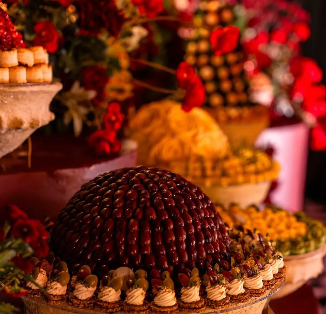 Close view of a chocolate dome and jewelled pastries in a stone bowl